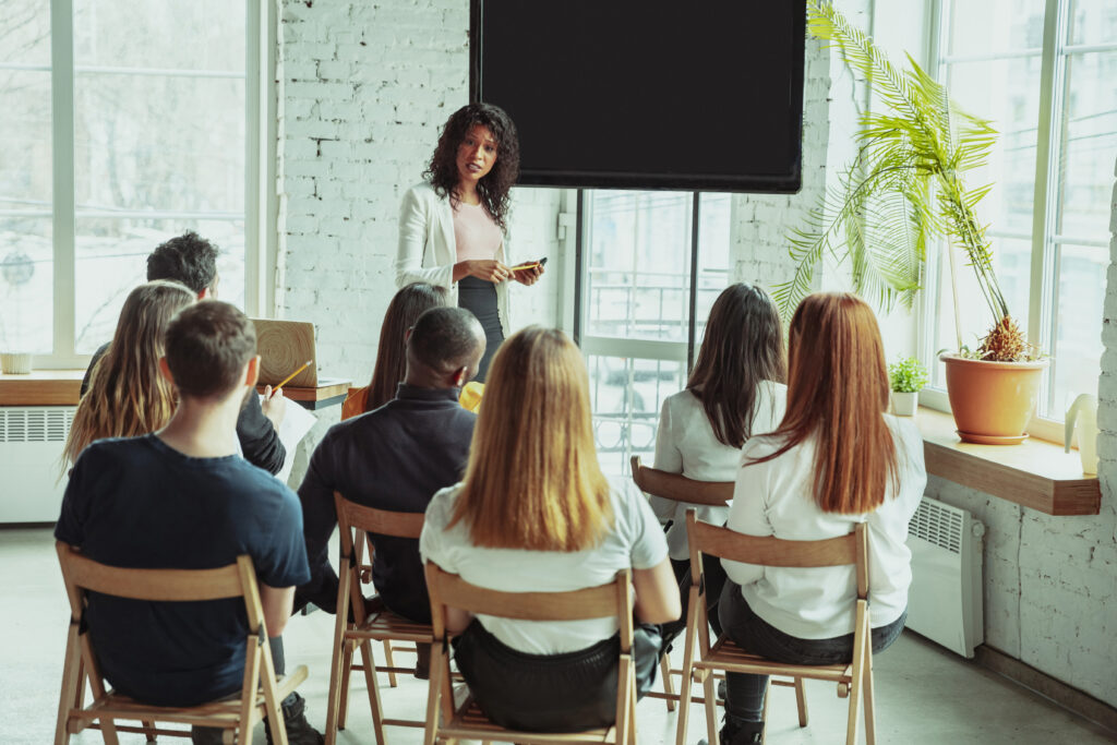 female african american speaker giving presentation in hall at university workshop scaled